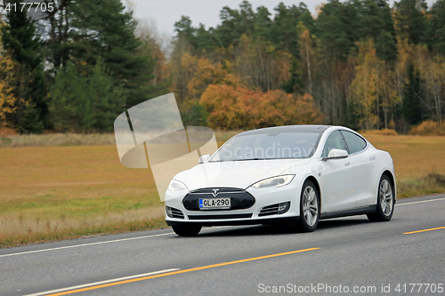 Image of White Tesla Electric Car at Speed in Autumn