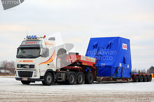 Image of White Volvo FH16 Semi Trailer Hauls Wide Load in Winter