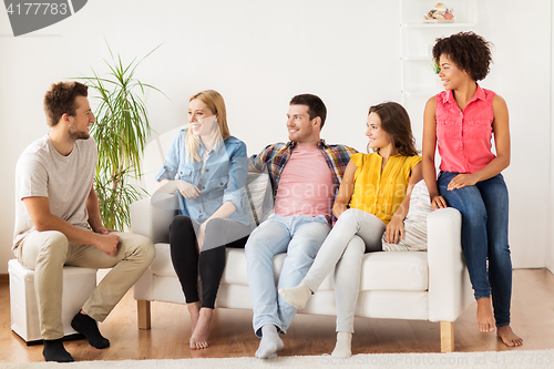 Image of group of happy friends talking at home