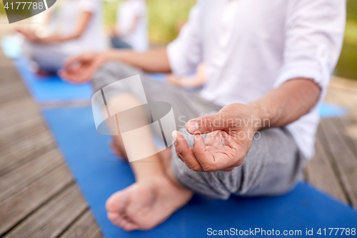 Image of close up of people making yoga exercises outdoors