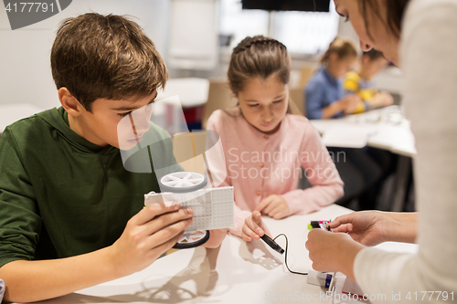 Image of happy children building robots at robotics school