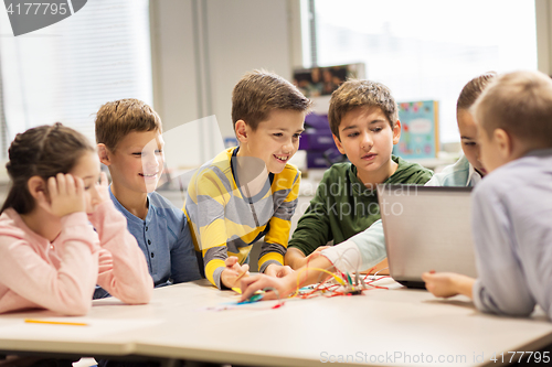 Image of happy children with laptop at robotics school