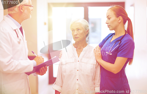 Image of medics and senior patient woman at hospital