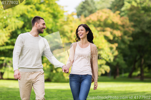Image of happy couple walking in summer park