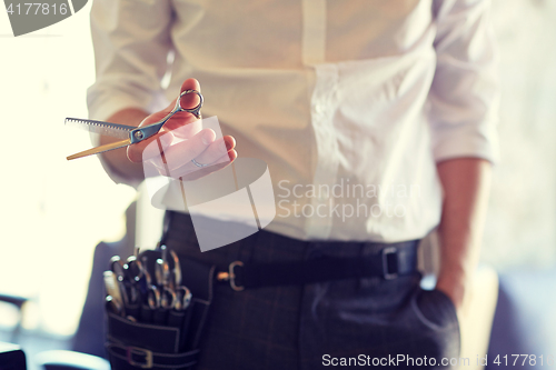 Image of close up of male stylist with scissors at salon