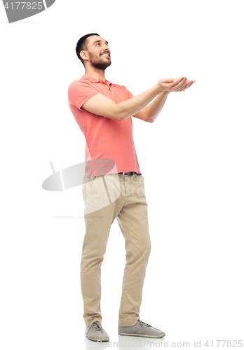 Image of happy man holding something imaginary on hands