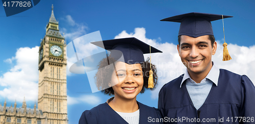 Image of happy students or bachelors in mortar boards