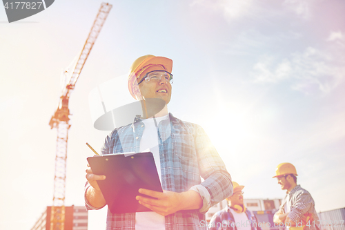 Image of builder in hardhat with clipboard at construction