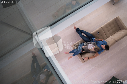 Image of youg couple in living room with tablet top view