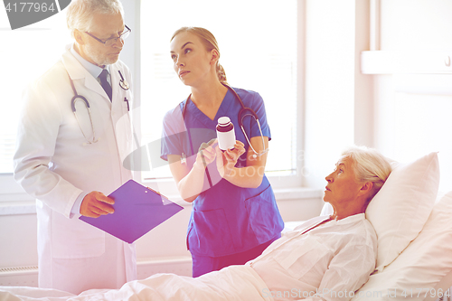 Image of doctor giving medicine to senior woman at hospital