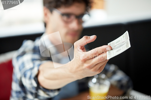 Image of man with cash money paying at cafe