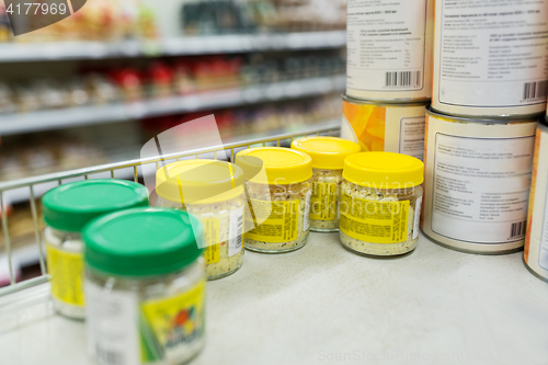 Image of jars with food or spices at grocery shelf