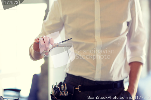 Image of close up of male stylist with scissors at salon