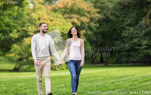 Image of happy couple walking in summer park