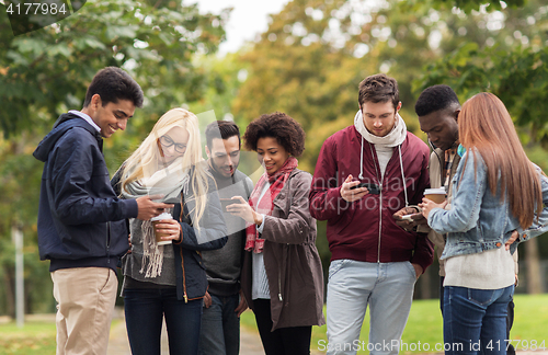 Image of happy friends with smartphone and coffee outdoors