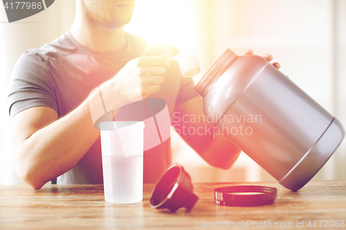 Image of close up of man with protein shake bottle and jar