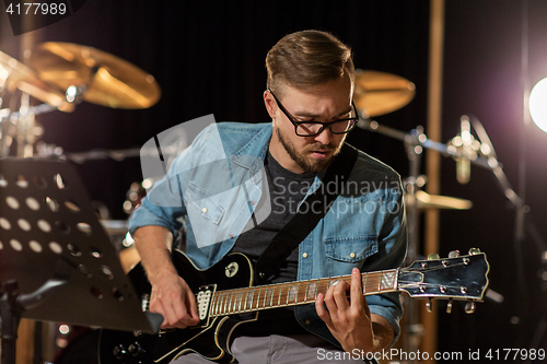 Image of man playing guitar at studio rehearsal