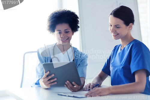 Image of happy doctors with tablet pc meeting at hospital