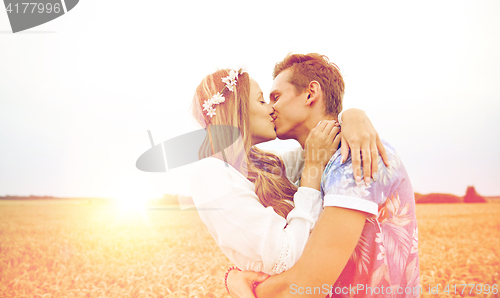 Image of happy young hippie couple kissing in field