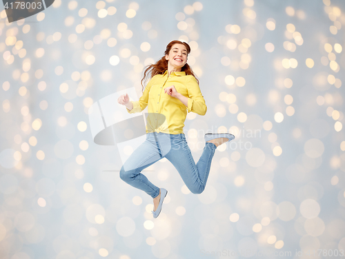 Image of smiling young woman jumping in air