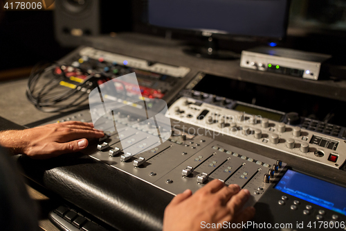 Image of man using mixing console in music recording studio