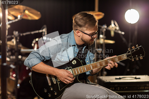 Image of man playing guitar at studio rehearsal