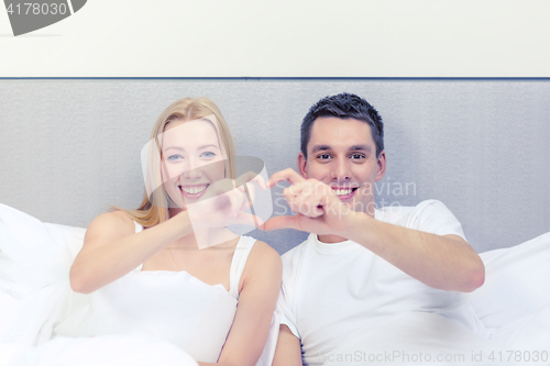 Image of smiling couple showing heart with hands