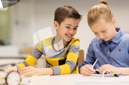 Image of happy children building robots at robotics school