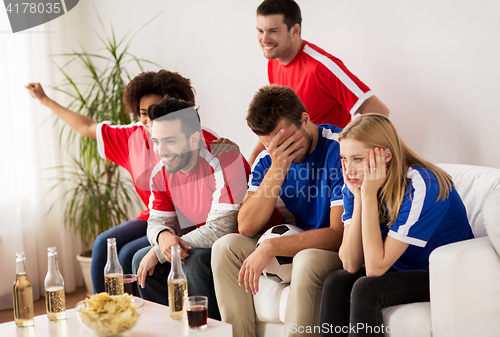 Image of friends or football fans watching soccer at home