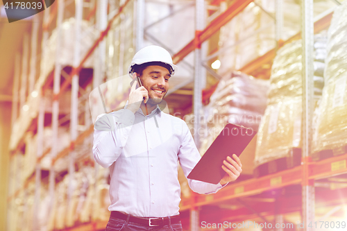 Image of man with clipboard and smartphone at warehouse