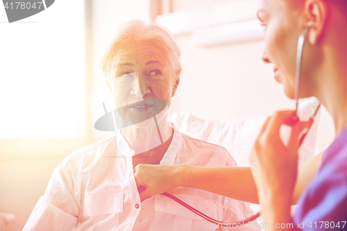 Image of nurse with stethoscope and senior woman at clinic