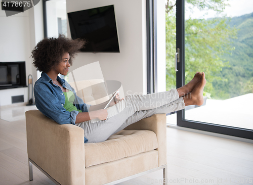 Image of african american woman at home with digital tablet