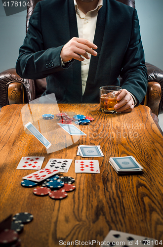 Image of The man, chips for gamblings, drink and playing cards