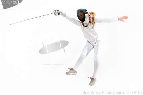 Image of Man wearing fencing suit practicing with sword against gray