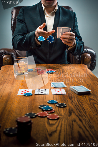 Image of The man, chips for gamblings, drink and playing cards