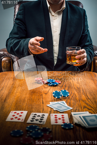 Image of The man, chips for gamblings, drink and playing cards