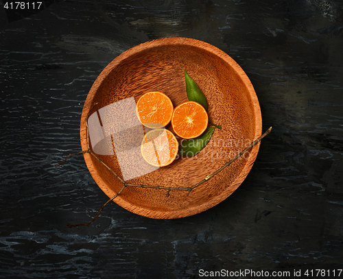 Image of The oranges citrus fruit halves on wooden plate