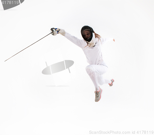 Image of Man wearing fencing suit practicing with sword against gray