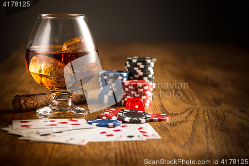 Image of Cigar, chips for gamblings, drink and playing cards