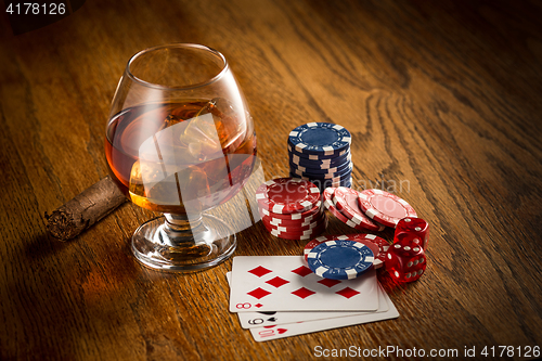 Image of Cigar, chips for gamblings, drink and playing cards