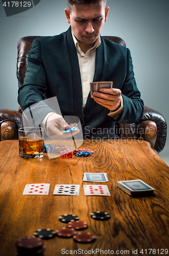 Image of The man, chips for gamblings, drink and playing cards