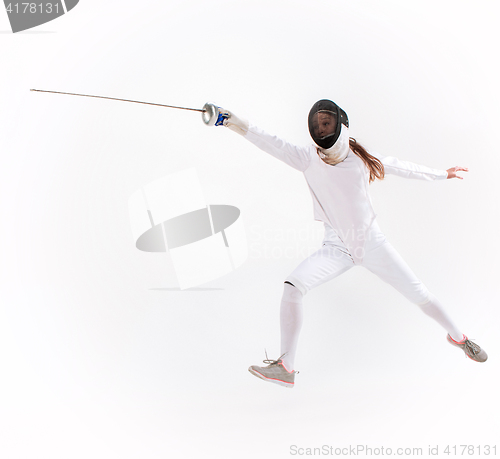 Image of Man wearing fencing suit practicing with sword against gray