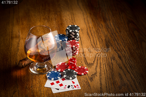 Image of Cigar, chips for gamblings, drink and playing cards