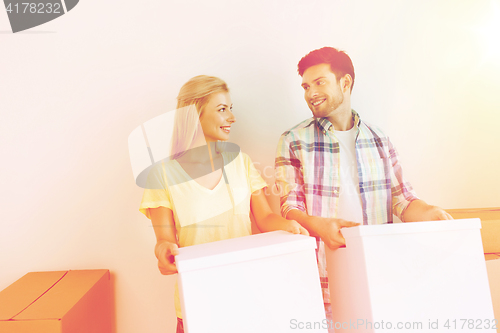 Image of smiling couple with big boxes moving to new home