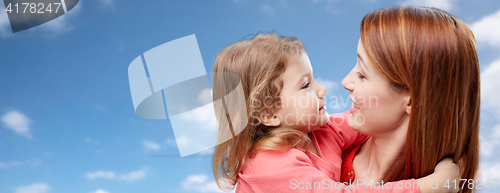 Image of happy mother and daughter hugging over blue sky