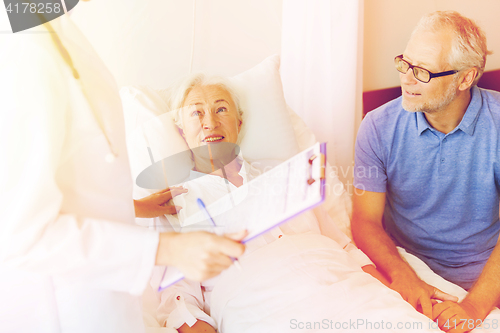 Image of senior woman and doctor with clipboard at hospital