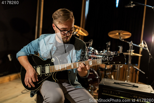 Image of man playing guitar at studio rehearsal