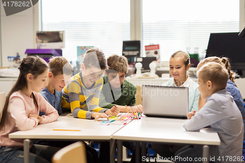 Image of happy children with laptop at robotics school