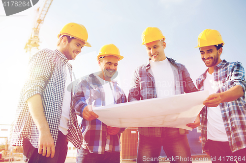 Image of group of builders with tablet pc and blueprint