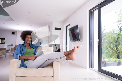 Image of african american woman at home with digital tablet